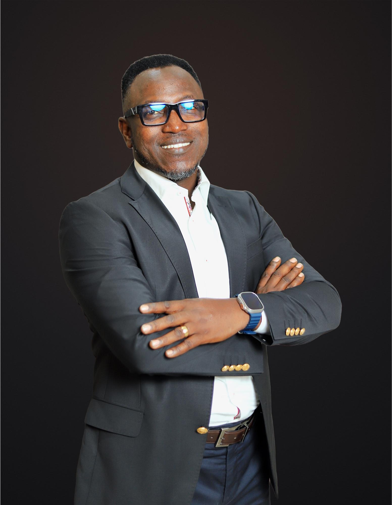 Dr. Sunday Olorunsheyi, arms crossed, smiling